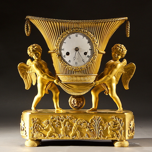 Antique Gilt Bronze Empire Clock. Gilt Bronze Mantel clock with two putti standing on oval base. Gilt bronze, France, 1810.