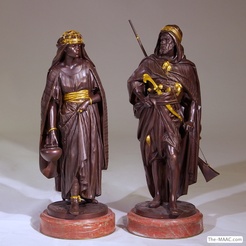 Pair of Orientalist Bronze Standing Figures. Pair of very fine patinated and gilt bronze orientalist figures of an Arab warrior and an Arab woman carrying water. Both on round marble bases. Inscribed Salmson on the bronze. Bronze and marble, France, 1880’s.