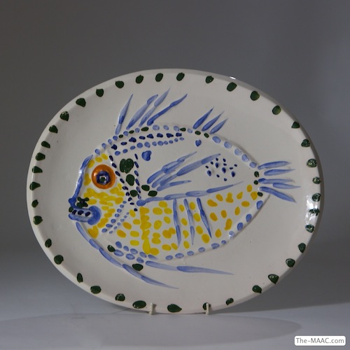 Pablo Picasso Pottery Platter. This platter titled by Picasso “Poisson Fond Blanc” is a glazed oval dish of white earthenware clay featuring a large fish in blue, yellow, and orange glazes. Signed and numbered 5/100. Illustrated catalogue raisonne of Picasso Ceramics by Ramie page 93, #168. White earthenware, France, 1952.