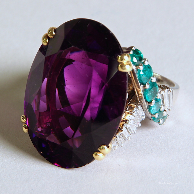 Large amethyst set in platinum and 18k yellow gold with diamond baguettes and round Colombian emeralds. Approximately 40 cts. 1940s.
