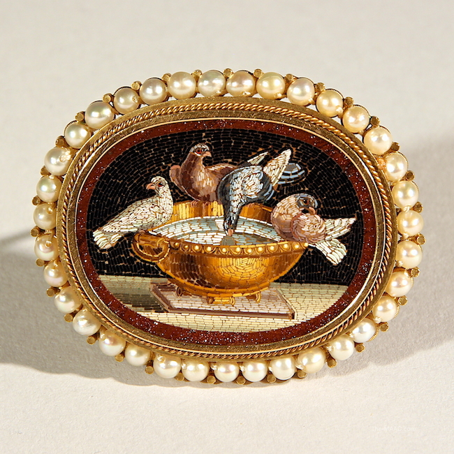 Antique Micro Mosaic Brooch. Micro mosaic brooch in excellent condition, tesserae on gold base depicting birds perched on golden tureen, brooch is surrounded by pearls. Gold, pearl, England. W: 2″ H: 1-1/2″