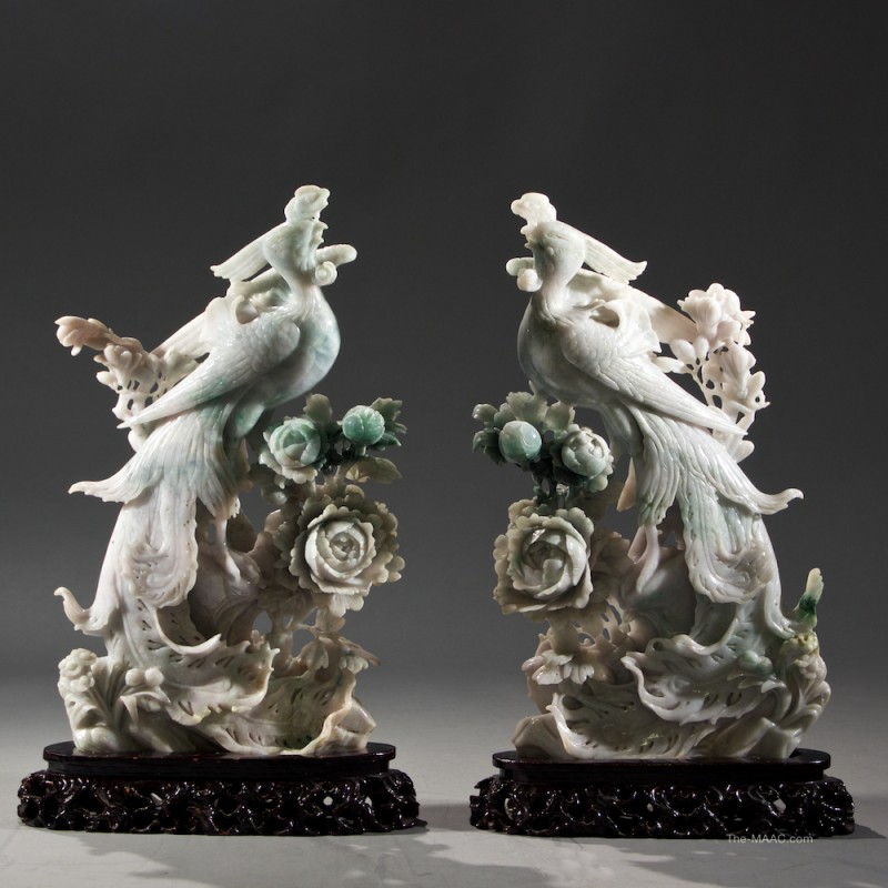 Pair of Chinese Jadeite Phoenixes. Very fine carved pair of phoenixes surrounded by peony flowers, seated on carved wooden bases. The jadeite stone has an apple green coloration with hints of purple. Jadeite, China, 1950-1970. [ Angela & J. Gallery - Gallery #53 ]