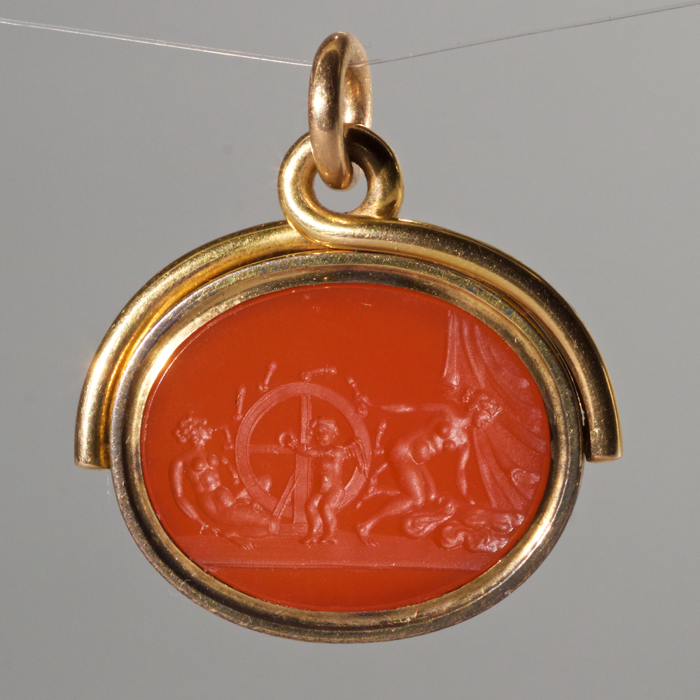 Antique pendant - gold surround an orange carnelian swivel seal. Erotic illustration.