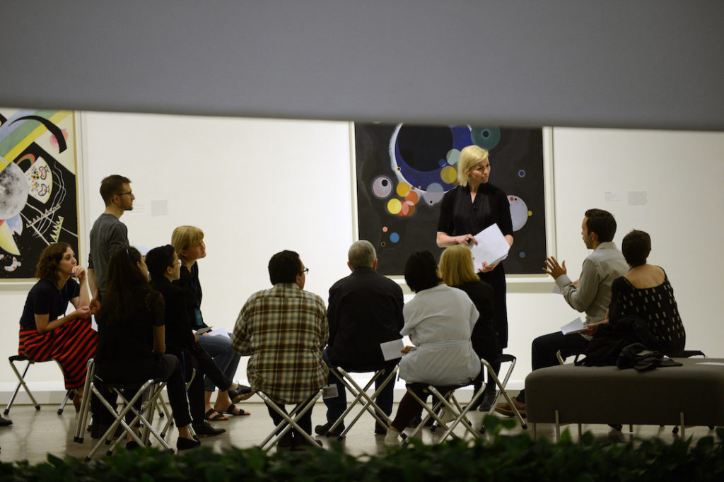 Museum Art Educator talks to audience in a gallery room
