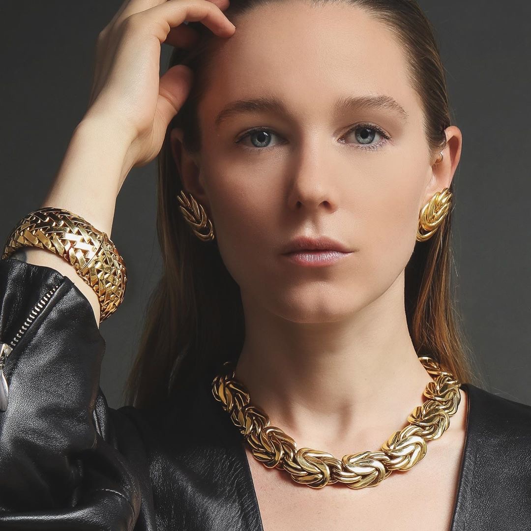 Woman wearing black jacket and 18 Karat Gold Bracelet, Earrings and Necklace